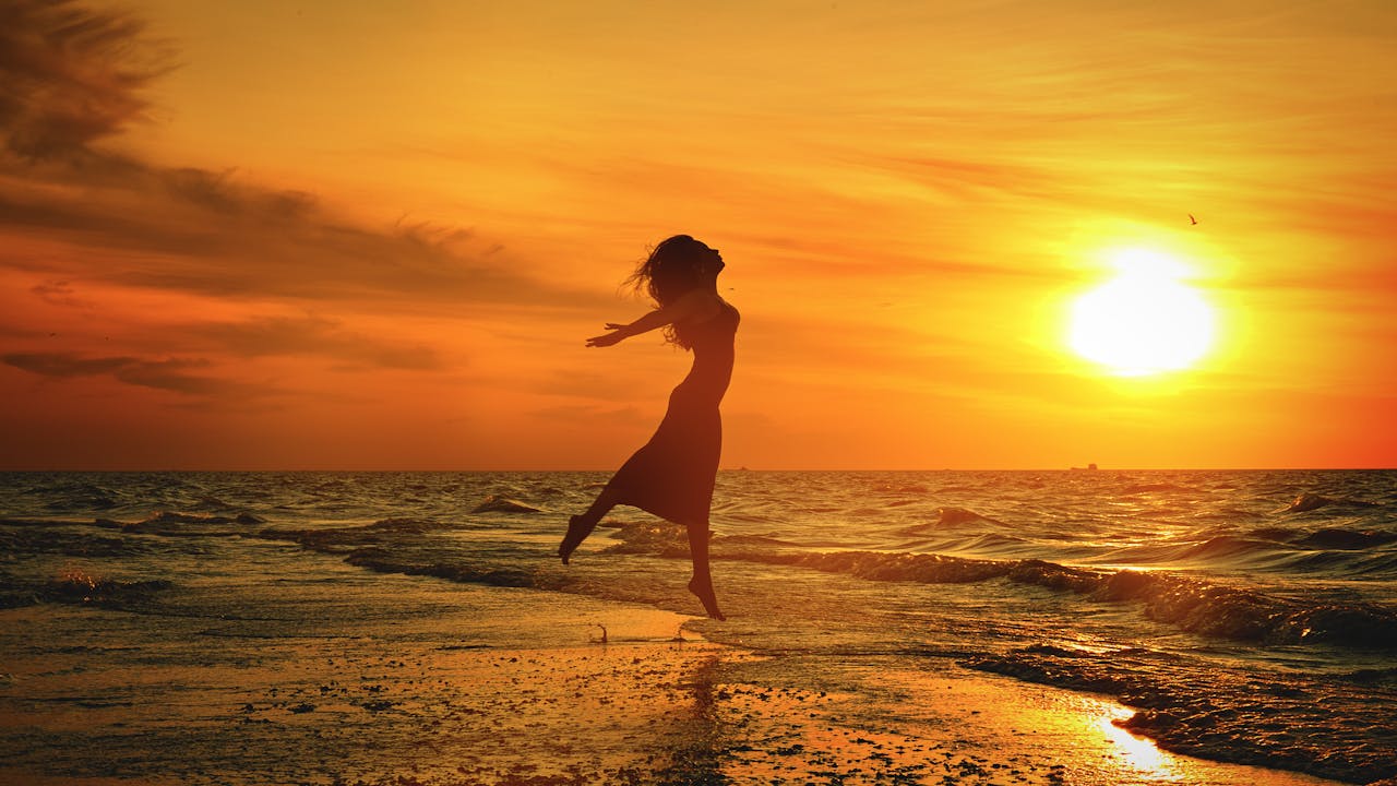 The Art of Drawing Readers In: Your attractive post title goes here Side view of anonymous barefoot female jumping with reached arms above sandy shore near wavy ocean under bright cloudy sky at sundown in twilight